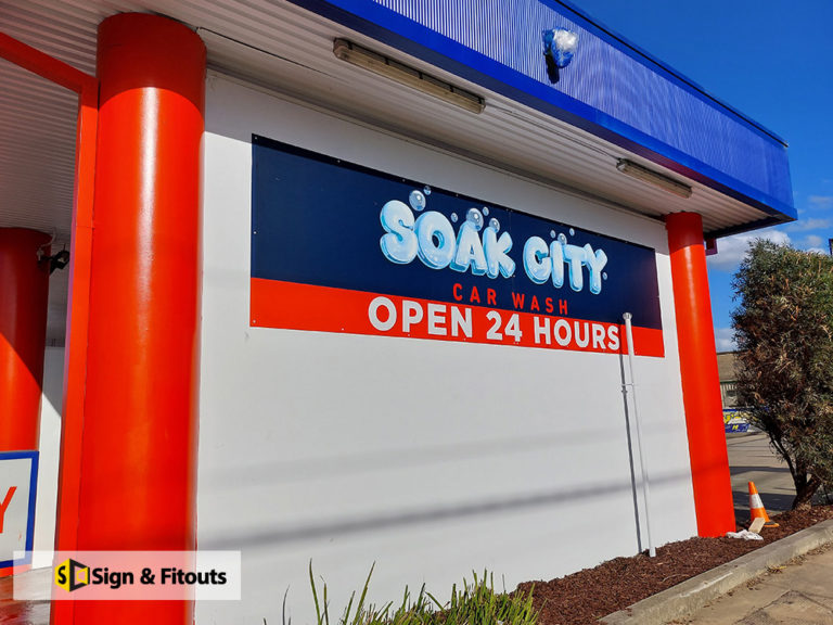Soak City Car Wash Open 24 Hours panel sign on a white wall in Preston